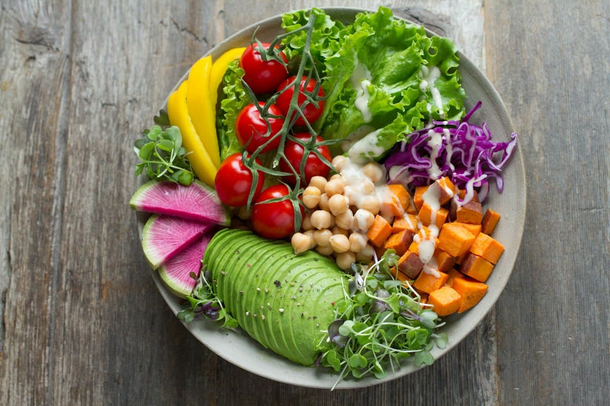 A bowl of salad with avocado, tomatoes, chickpeas and sweet potato